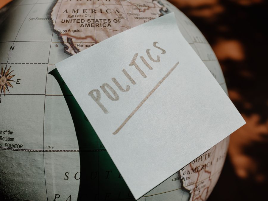 A note reading Politics resting on a globe turned to North America